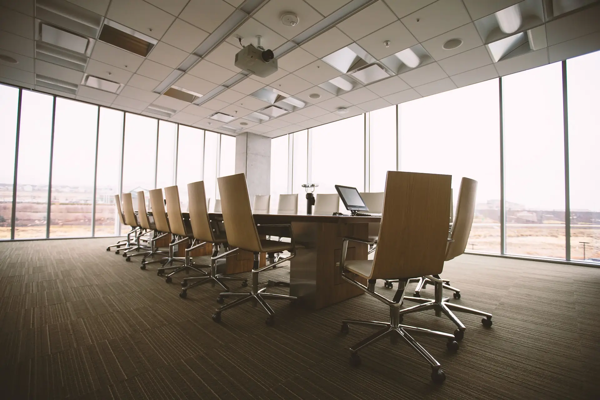 Boardroom with a long table and chairs facing tall windows
