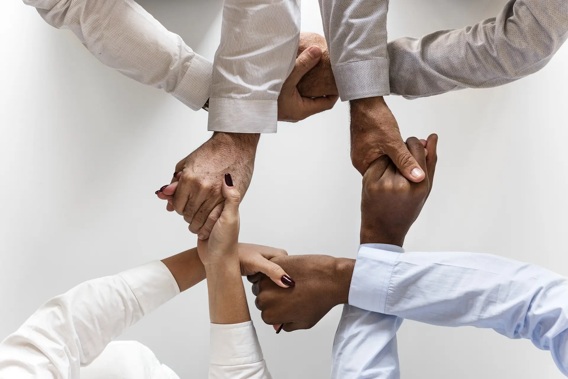 Colleagues joining hands in a circle, seen from above